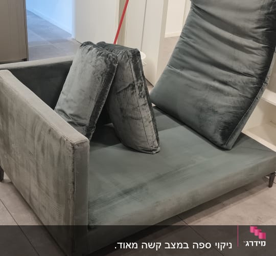 ספה עם כריות ומכונת ניקוי בצד